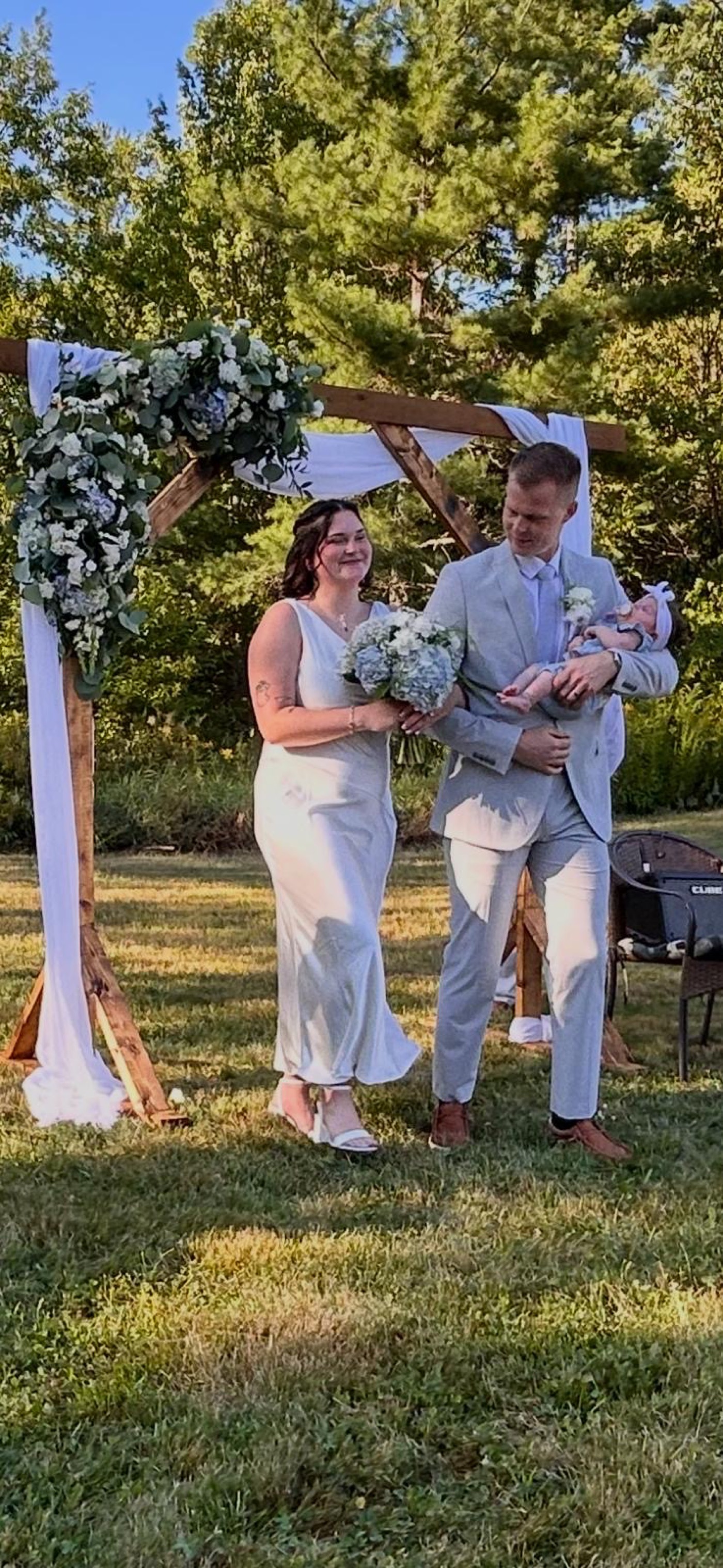 Newlyweds beneath a Maine Arch Co. arch
